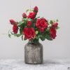 Red lifelike roses in vase