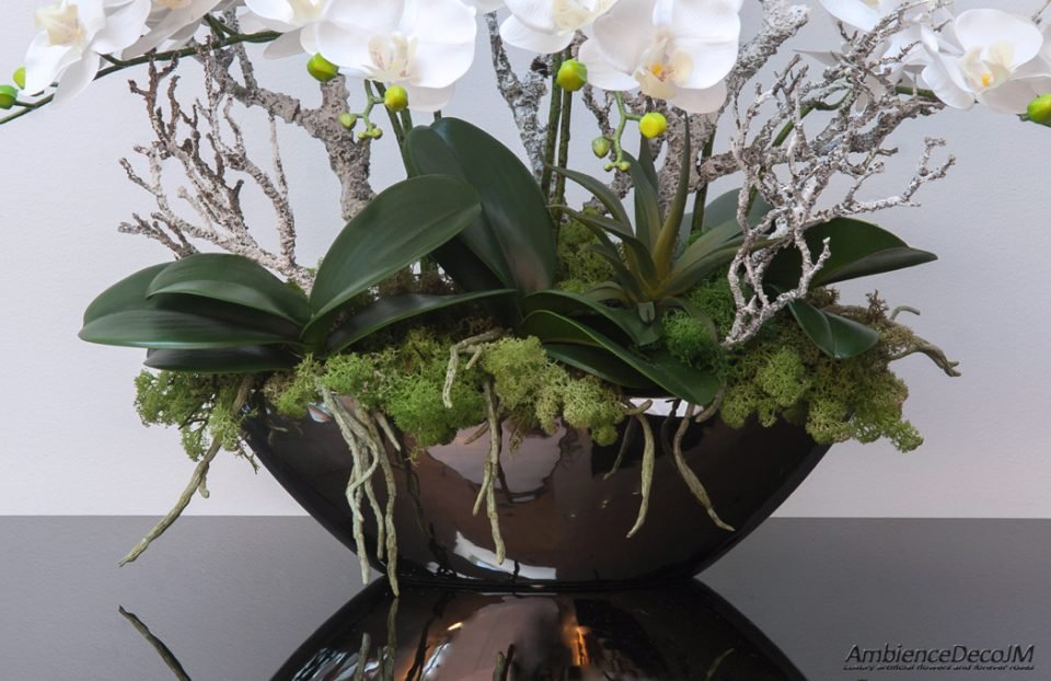 Lifelike orchids in a mirrored boat vase