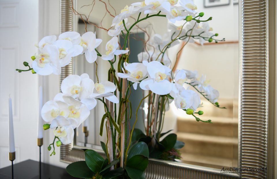 Faux orchids in a glass bowl