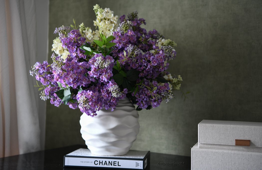 Luxury faux lilac arrangement featuring premium real-touch purple and ivory lilac blooms arranged in a contemporary white ceramic vase. Elegant artificial floral centrepiece for dining tables, console tables, and luxury home décor.