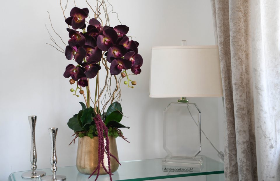 Luxury plum artificial Phalaenopsis orchid arrangement in a gold planter with decorative branches and premium faux flowers by AmbienceDecoJM.