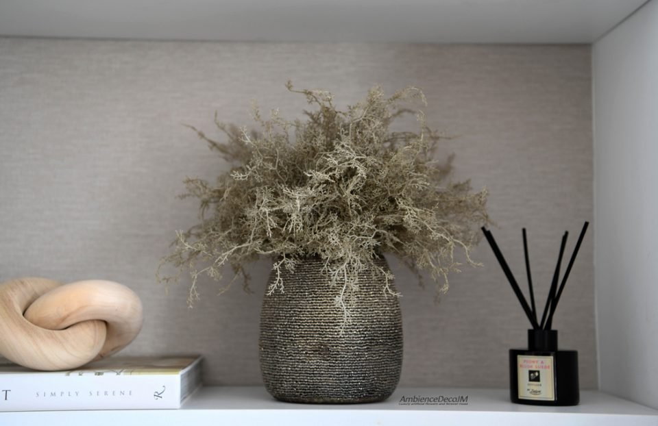 Luxury artificial foliage arrangement with muted green and taupe foliage in a beaded glass vase